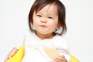 Japanese baby girl eating rice cracker (0 year old)